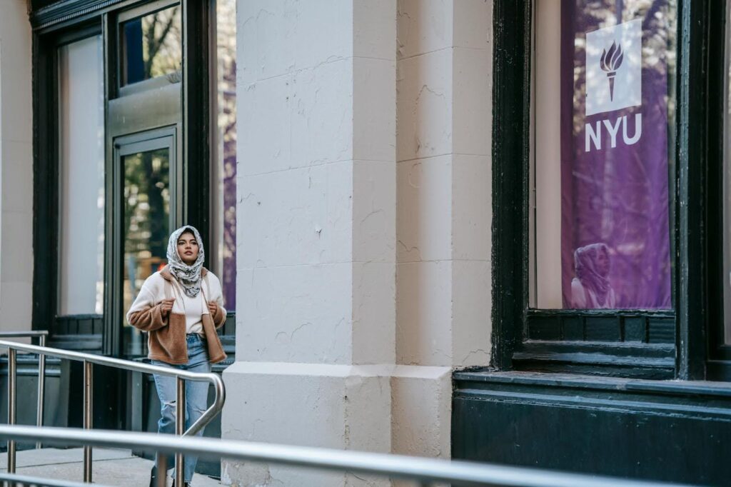 Student walking outside NYU building.