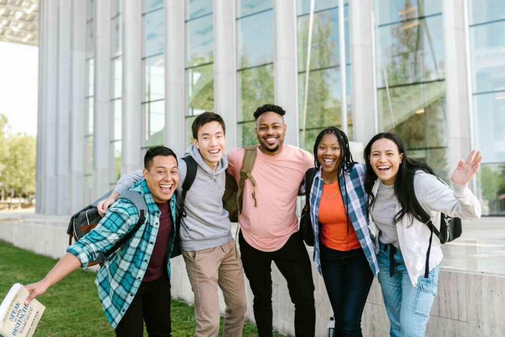 Group of diverse students smiling outside a university building