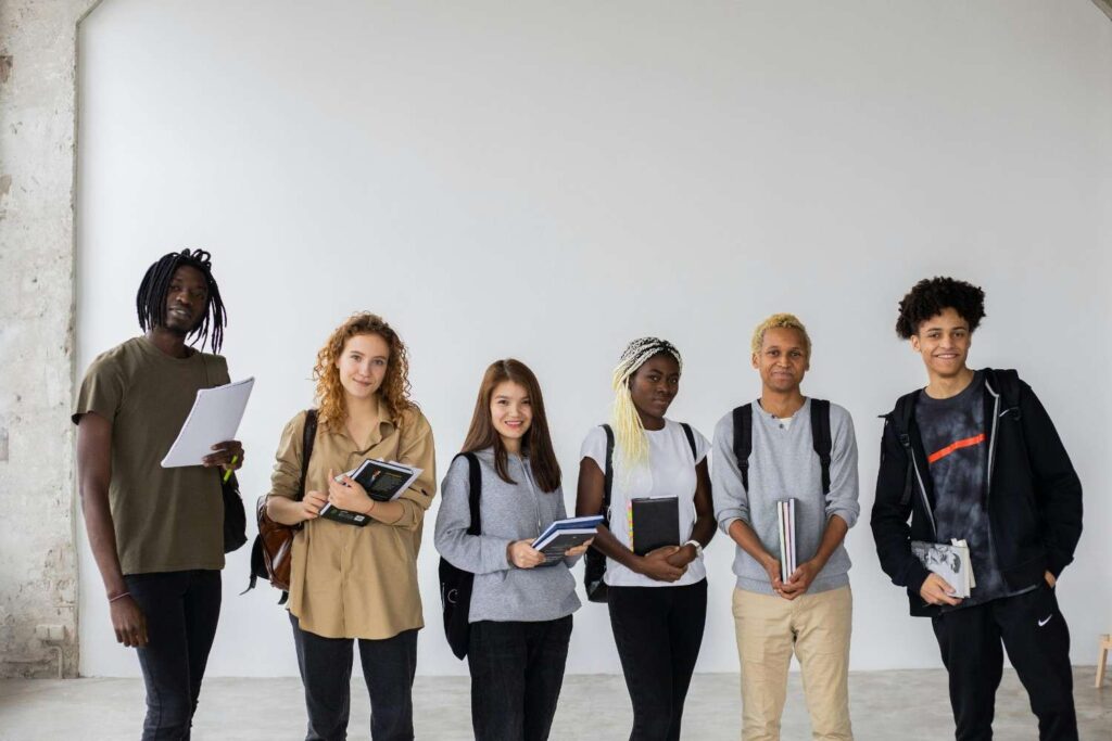 Diverse group of students standing with books and backpacks