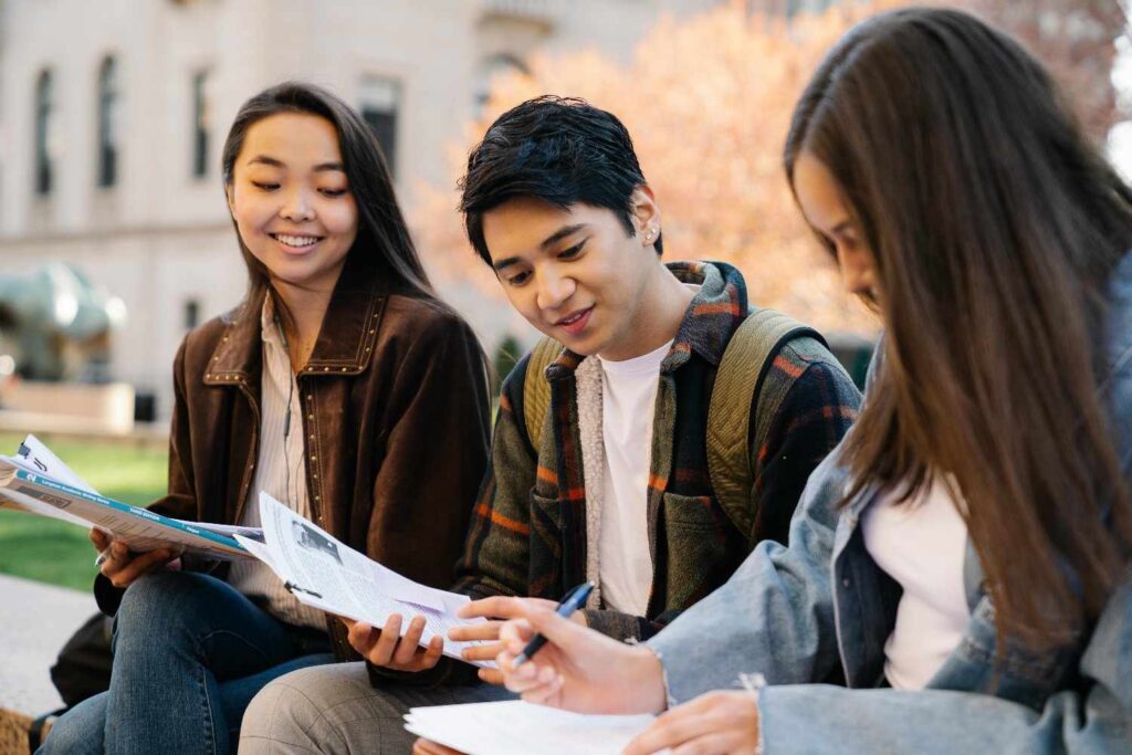 Group of international students studying together outdoors