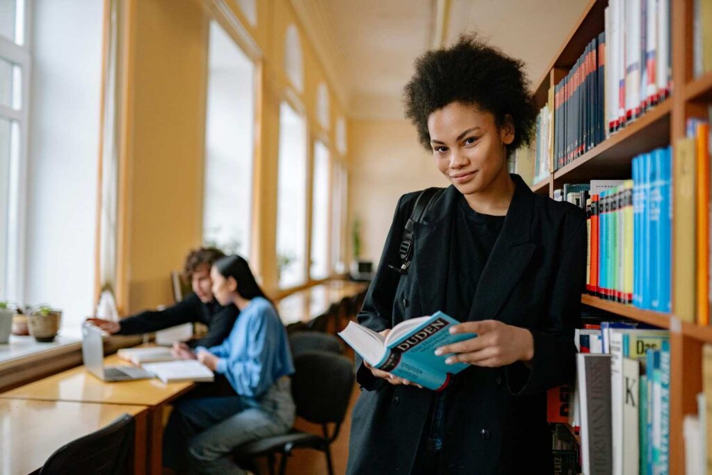 Student holding a book in the library