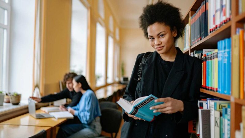 Student holding a book in the library