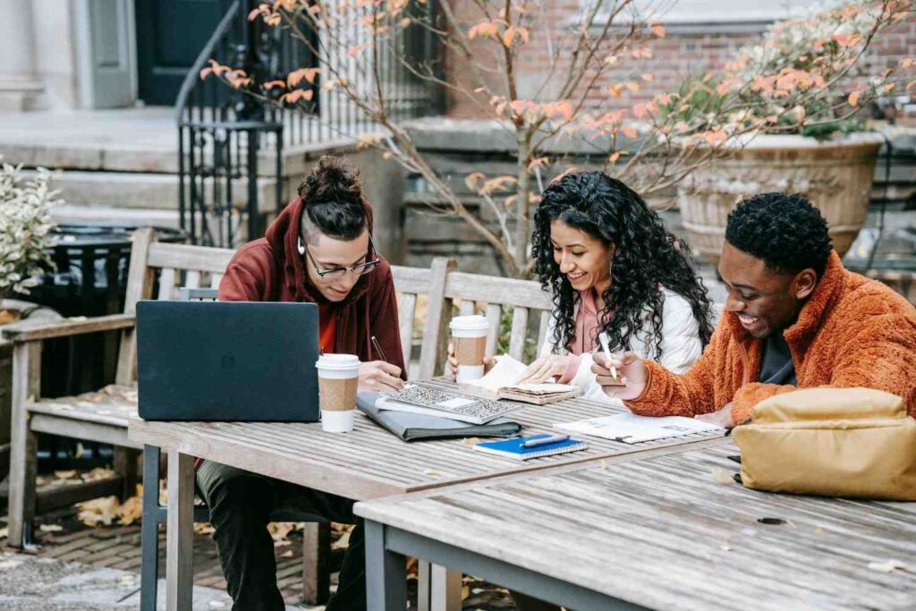 Cheerful multiethnic students studying at a table