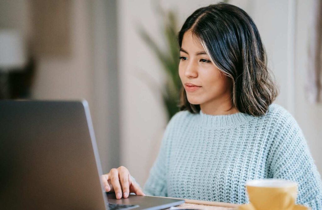 female student using a laptop in a room
