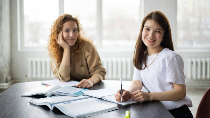 Two people smiling with papers on the table