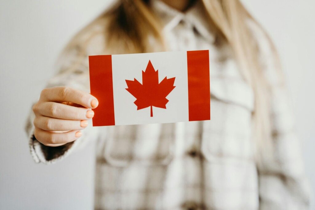 A person holding a small Canadian flag