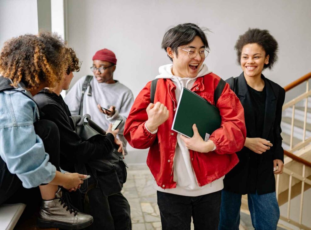 A group of diverse college students happily interacting indoors